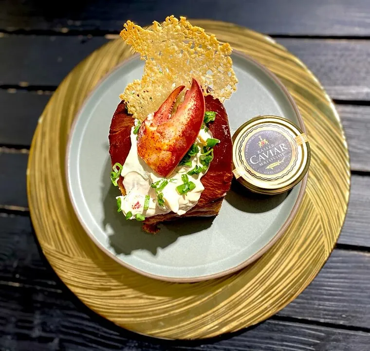 Angerichtetes Gericht mit Fleisch, Salat und Sauce